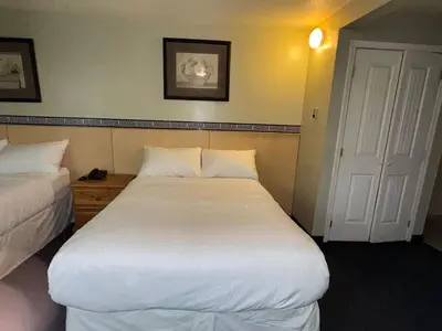 a hotel room with two beds and a door at Silver crest lodge in Grande Prairie