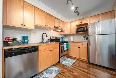 a kitchen with wooden cabinets and a stainless steel refrigerator at Rocky Mountain Oasis-Mountain View! in Canmore