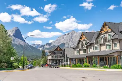 a street in a town with mountains in the background at Rocky Mountain Oasis-Mountain View! in Canmore