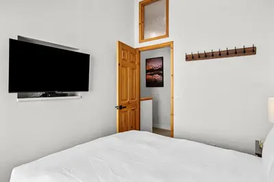 a bedroom with a bed and a flat screen tv at 2BR 2BA Harvie Heights Townhouse retreat with views in Canmore