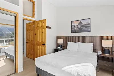 a bedroom with a large bed and a window at 2BR 2BA Harvie Heights Townhouse retreat with views in Canmore