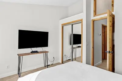 a bedroom with a flat screen tv on a wall at 2BR 2BA Harvie Heights Townhouse retreat with views in Canmore