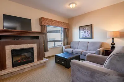 a living room with a couch and a fireplace at Canalta High River in High River