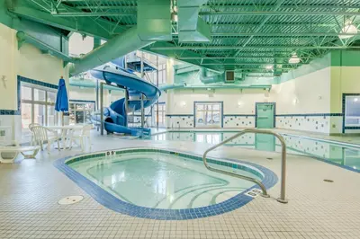 a swimming pool with a slide in a building at Canalta High River in High River