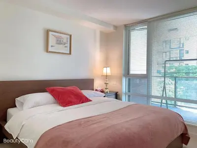 a bedroom with a large bed with a red pillow at Comfort in Richmond center 2bedr & good location in Richmond