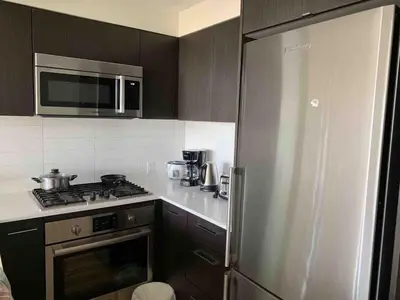 a kitchen with a refrigerator and a stove top oven at Comfort in Richmond center 2bedr & good location in Richmond