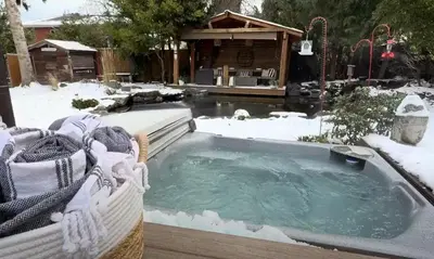 a jacuzzi tub in the snow in a yard at Couple's Oasis at Horner Park in Victoria