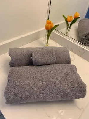 a pile of towels sitting on a table with flowers at Amazing brand new 2bedr&2bathr in Richmond center in Richmond