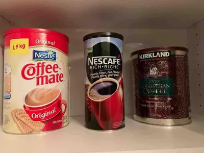 a refrigerator with three cans of coffee and a cup of coffee at Amazing brand new 2bedr&2bathr in Richmond center in Richmond