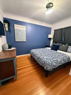 a bedroom with a bed and a blue wall at Family Cottage at Horner Park in Victoria