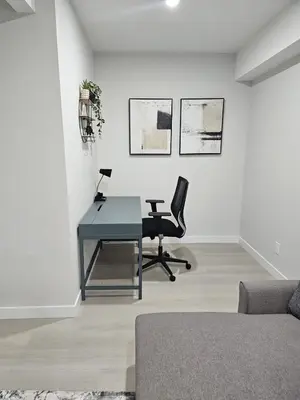 an office with a desk and chairs in a room at Brand-New Guesthouse-2bedrooms in Calgary