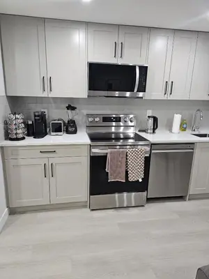 a kitchen with a stove and a microwave at Brand-New Guesthouse-2bedrooms in Calgary