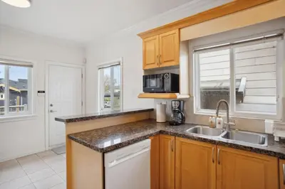 a kitchen with a sink and a microwave at Bright and Comfy 3BR Home Ideal for Families in Vancouver