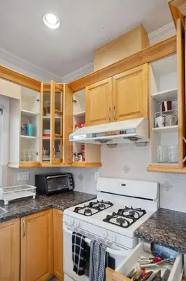 a kitchen with a white stove and wooden cabinets at Bright and Comfy 3BR Home Ideal for Families in Vancouver