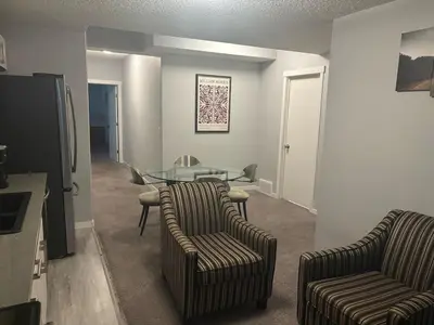 a living room with two chairs and a glass table at Spacious 2BR Suite - SW Edmonton in Edmonton