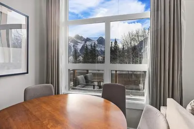 a dining room with a table and a large window at Township by Canmore Premier in Canmore