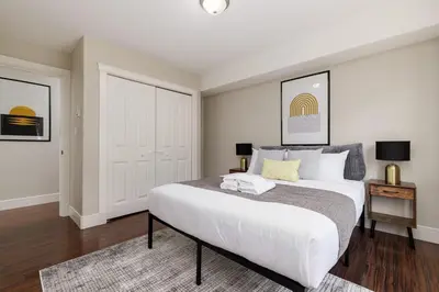 a bedroom with a large white bed and a rug at Peaceful spacious 2BR Suite in Nanaimo