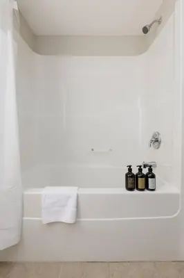 a bathroom with three bottles of essential oils on a bathtub at Peaceful spacious 2BR Suite in Nanaimo