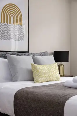 a bedroom with a large bed with a yellow pillow at Peaceful spacious 2BR Suite in Nanaimo