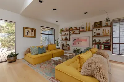 a living room with two yellow couches and a rug at The Cougar Den in Tofino