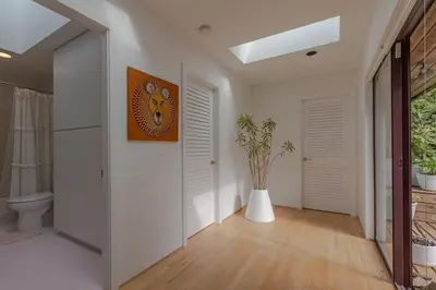 a hallway with white walls and a clock on the wall at The Cougar Den in Tofino