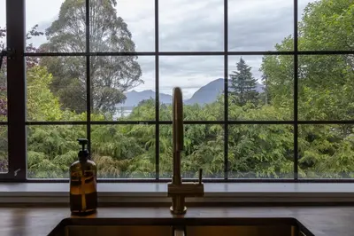 a kitchen counter with a window looking out at the forest at The Cougar Den in Tofino