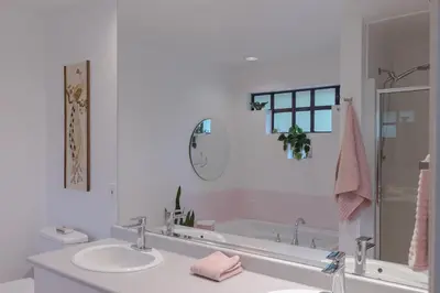a white bathroom with a sink and a tub at The Cougar Den in Tofino
