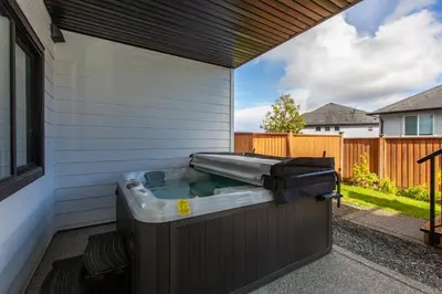 a hot tub on the side of a house at Cozy Garden Suite with Hot Tub and Perfectly Located in Goldstream Station