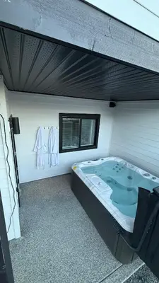 a room with a jacuzzi tub in a building at Cozy Garden Suite with Hot Tub and Perfectly Located in Goldstream Station