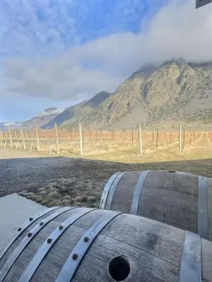a barrel sitting on the side of a road with a mountain at Spacious Getaway Two Homes on a Tranquil Vineyard Ideal for Large Groups in Keremeos