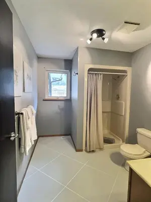 a bathroom with a toilet and a shower at Spacious Getaway Two Homes on a Tranquil Vineyard Ideal for Large Groups in Keremeos