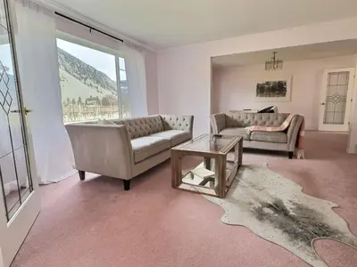 a living room with two couches and a table at Spacious Getaway Two Homes on a Tranquil Vineyard Ideal for Large Groups in Keremeos