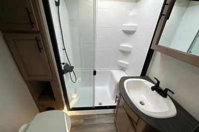 a bathroom with a shower and a sink and a toilet at Fernie RV Resort in Fernie