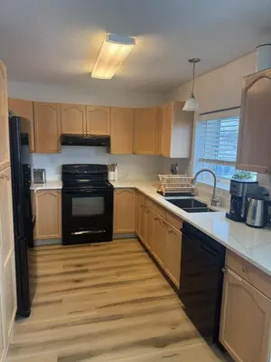a kitchen with wooden cabinets and a black appliances at Alpenglow Oasis in Hinton