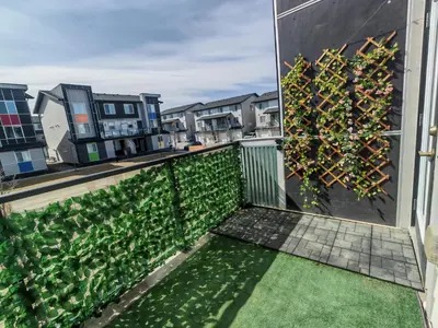 a balcony with green plants on the side of a building at Sunlit Haven in Calgary