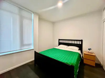 a bedroom with a bed with green sheets and a window at Best location &comfortable room1B &1B Richmond center in Richmond