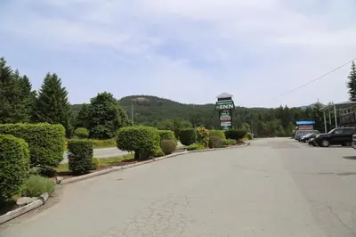 an empty street with a gas station sign and trees at Timberlodge RV & Campground in Port Alberni