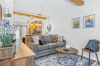 a living room with a couch and a table at Scenic 2BR Haven with MTN Views Near DT Banff in Canmore