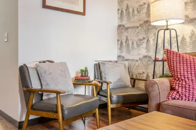 a living room with two chairs and a couch at 2BR Mystic Springs Escape with BBQ, Pool, Hot tub in Canmore
