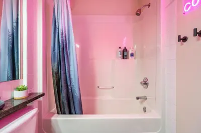 a pink bathroom with a tub and a shower at 2BR Mystic Springs Escape with BBQ, Pool, Hot tub in Canmore