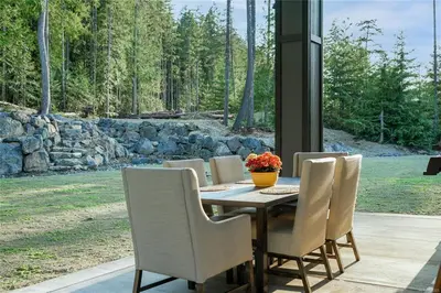 a dining room table with chairs and a table at Shawnigan Lake Retreat with Theatre in Shawnigan Lake
