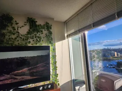 a room with a large window with a view of a river at Modern High-Rise 1 Bedroom Condo with water view near stadiums in Vancouver