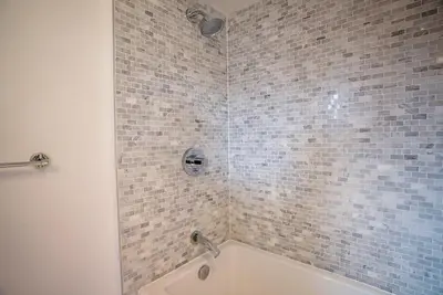 a bathroom with a shower with a tub and a sink at #Modern & Cozy 2BR 2BA in the Heart of Chinatown in Vancouver