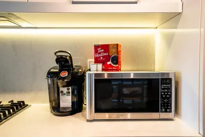 a microwave sitting on a counter next to a stove at #Modern & Cozy 2BR 2BA in the Heart of Chinatown in Vancouver