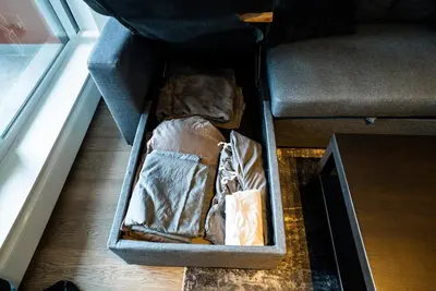 a box sitting on the floor next to a couch at #Modern & Cozy 2BR 2BA in the Heart of Chinatown in Vancouver