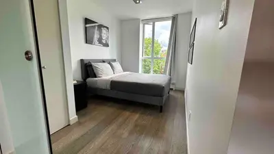 a bedroom with a bed and a window at #Modern & Cozy 2BR 2BA in the Heart of Chinatown in Vancouver