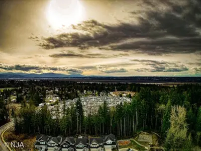 an aerial view of a city with houses and trees at Birdie on the Hill in Mission City