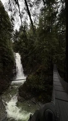 a person standing on a bridge near a waterfall at Birdie on the Hill in Mission City
