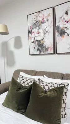 a bedroom with a bed with two paintings on the wall at Birdie on the Hill in Mission City
