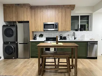 a kitchen with green cabinets and a wooden table at Birdie on the Hill in Mission City